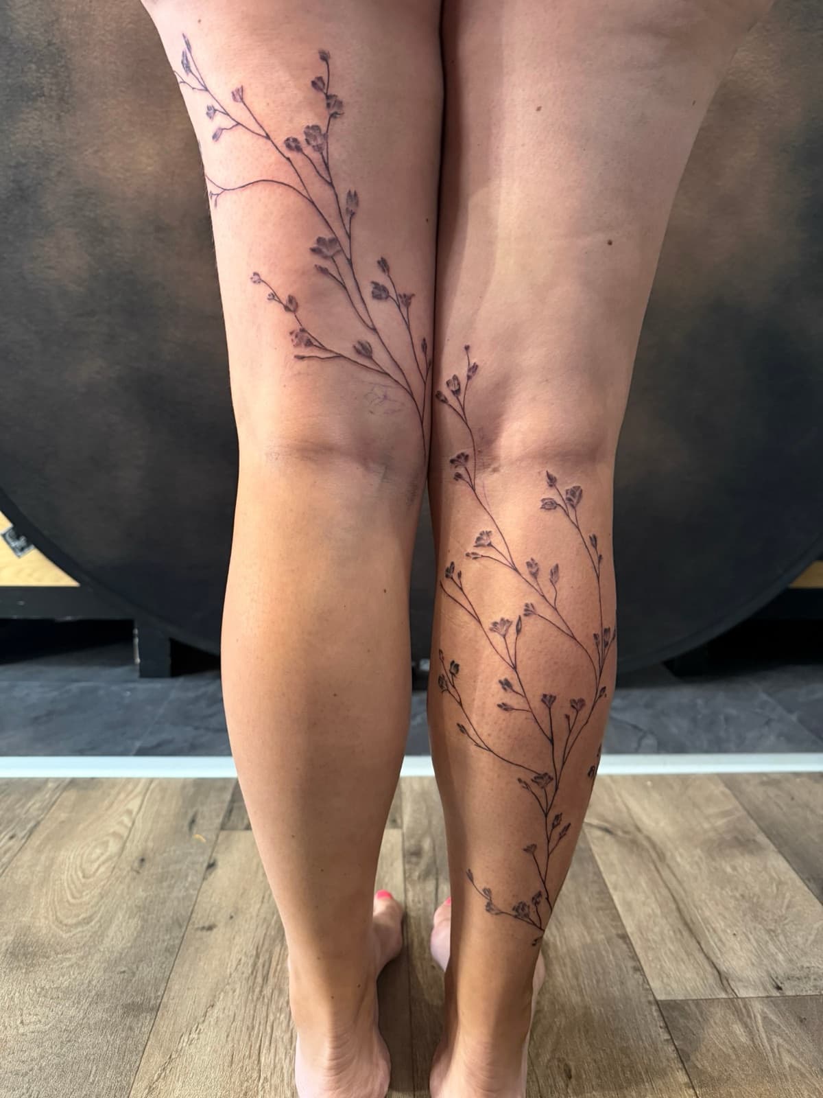 Tatouage de branches sur les jambes, réalisé au salon