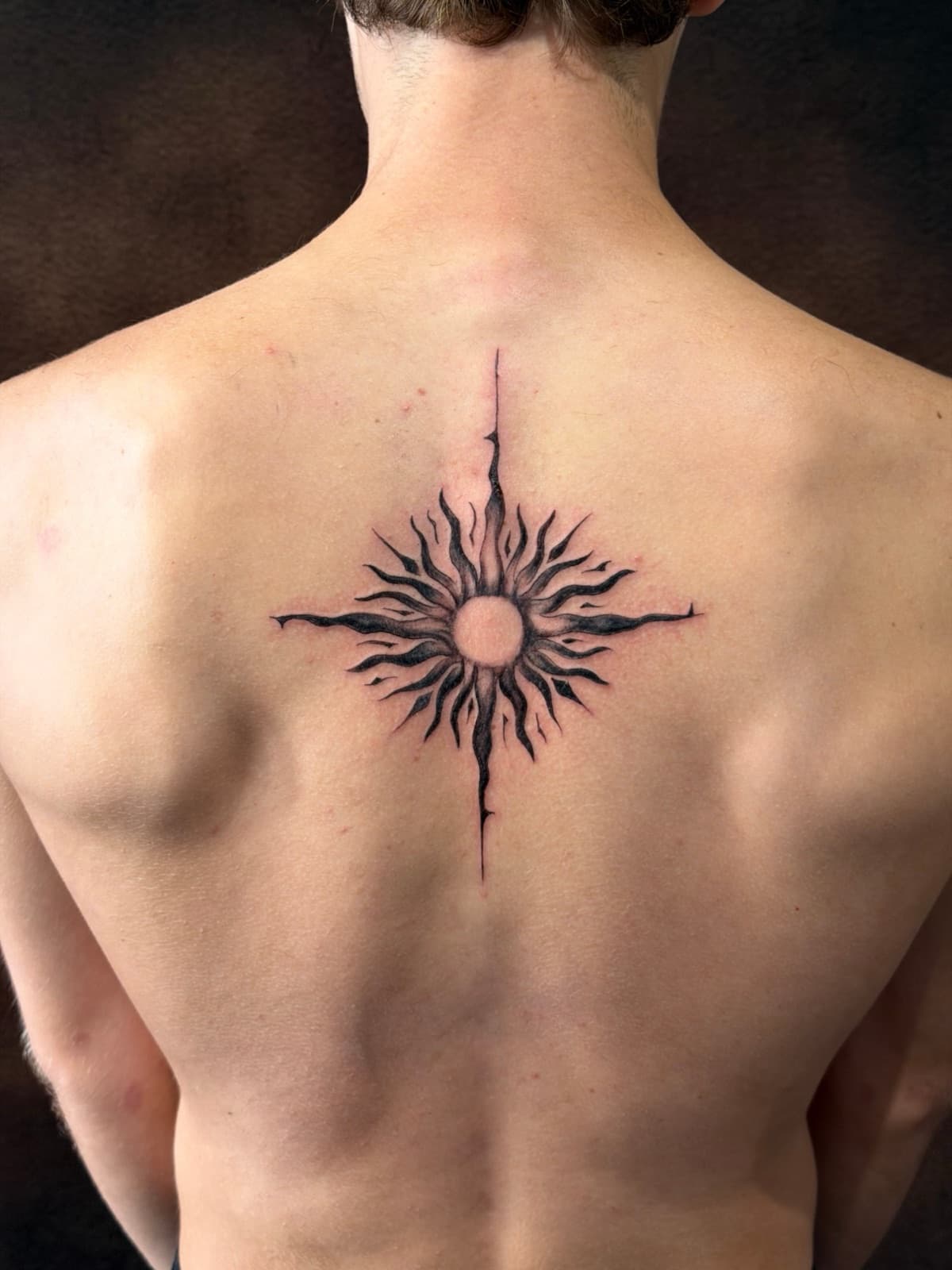 Tatouage d'un soleil dans le dos, réalisé au salon